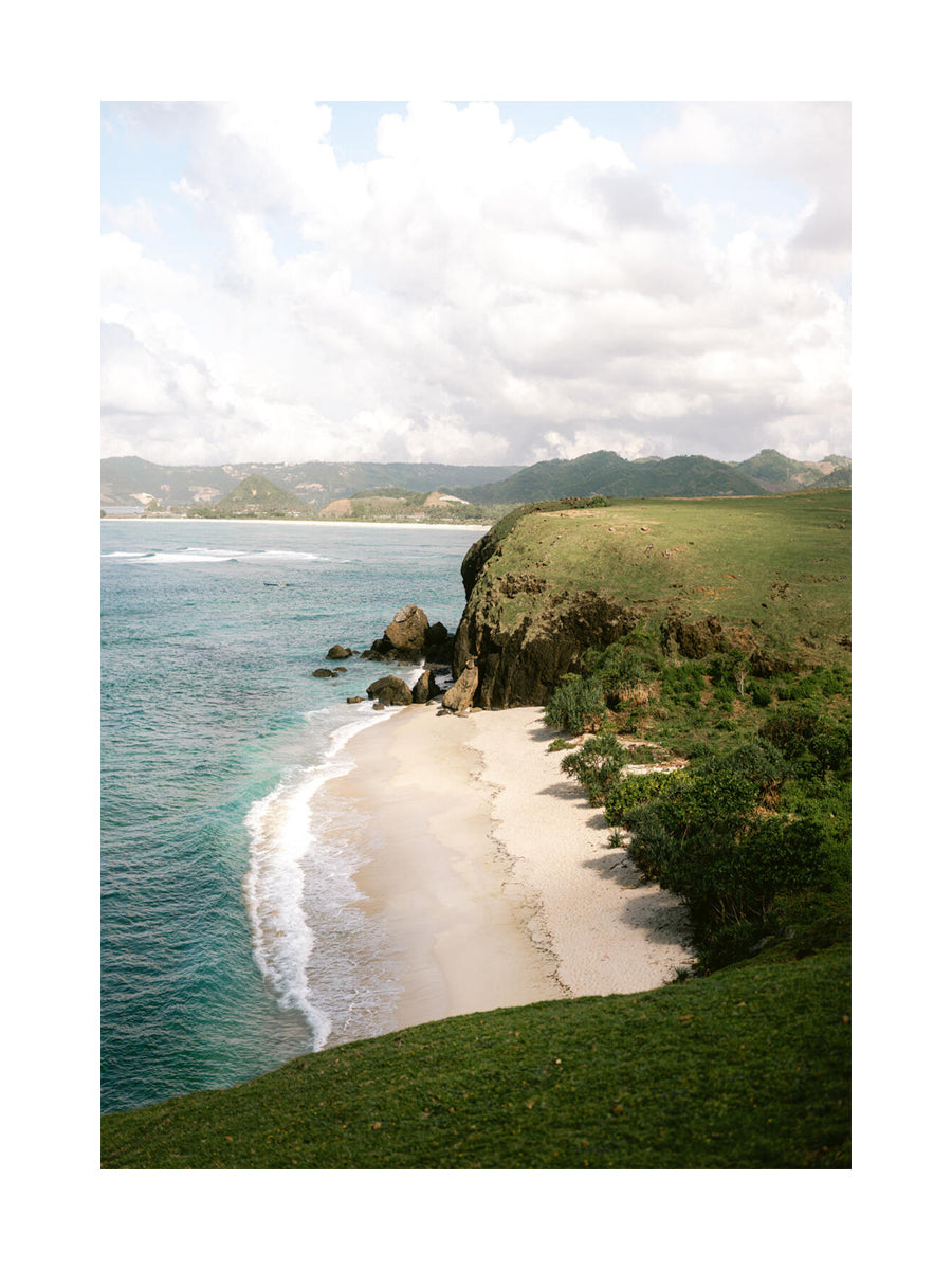 Fotografie eines Strandes mit Klippe und blauem Meer bei Lombok Beach.