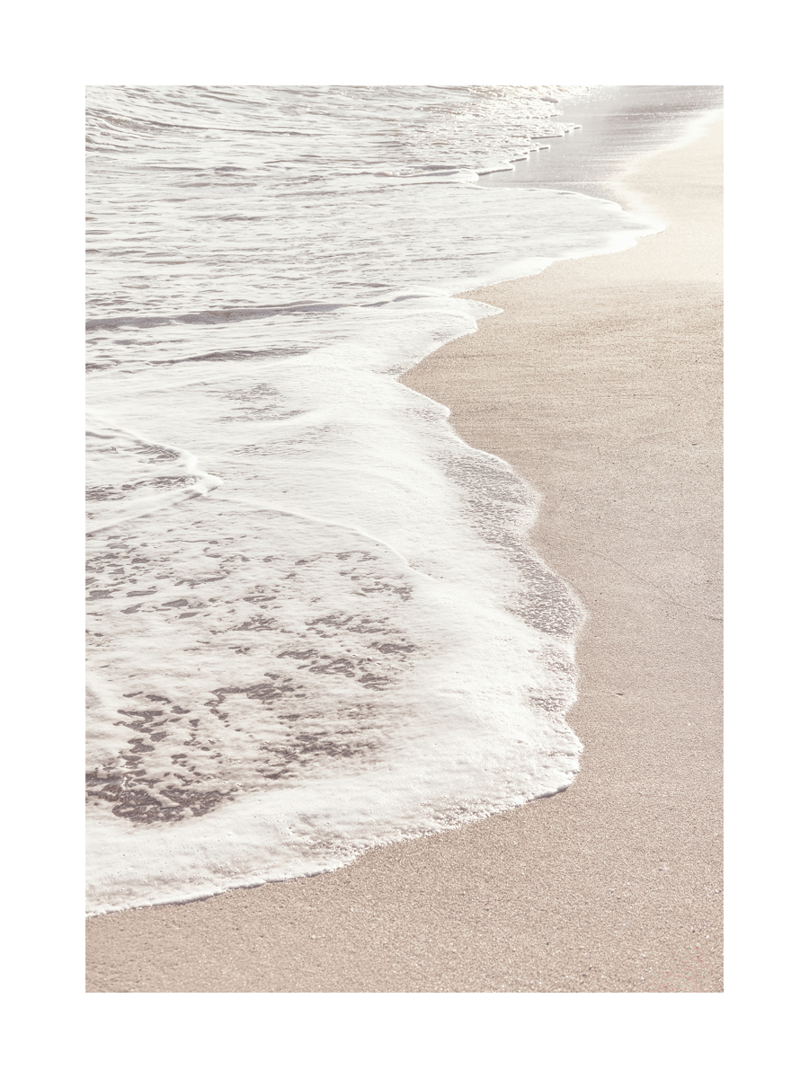 Fotografie von Wellen, die am Strand auf den Sand treffen.