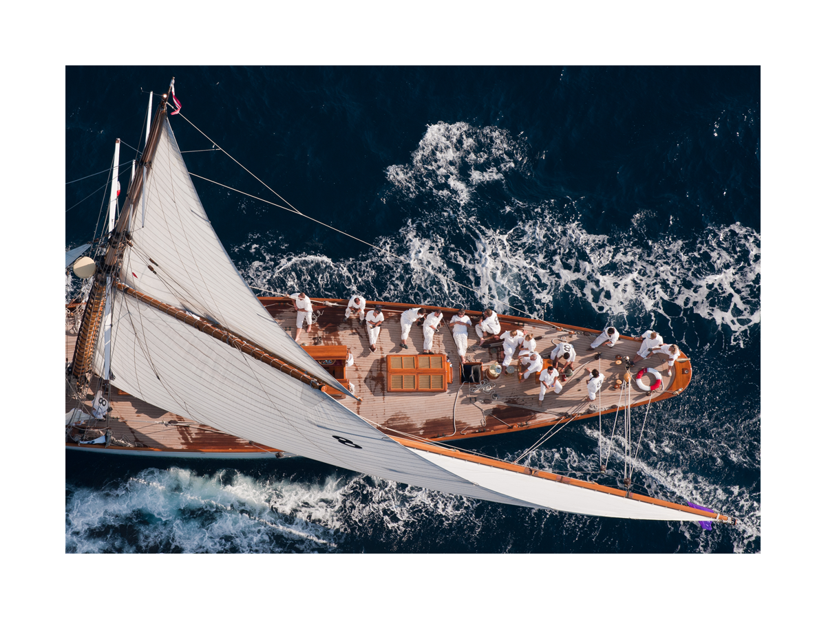 Fotoposter eines Segelboots im tiefblauen Ozean mit Crew in weißer Kleidung.