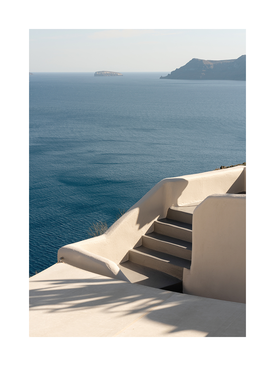 Fotografie einer Treppe mit Blick auf das blaue Meer und Inseln im Hintergrund.