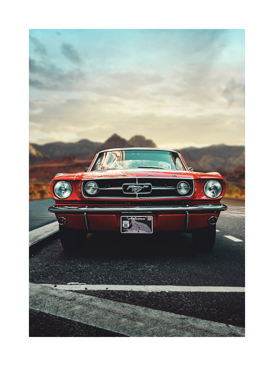 Ein roter Mustang auf einer Straße mit Bergen und Himmel im Hintergrund.