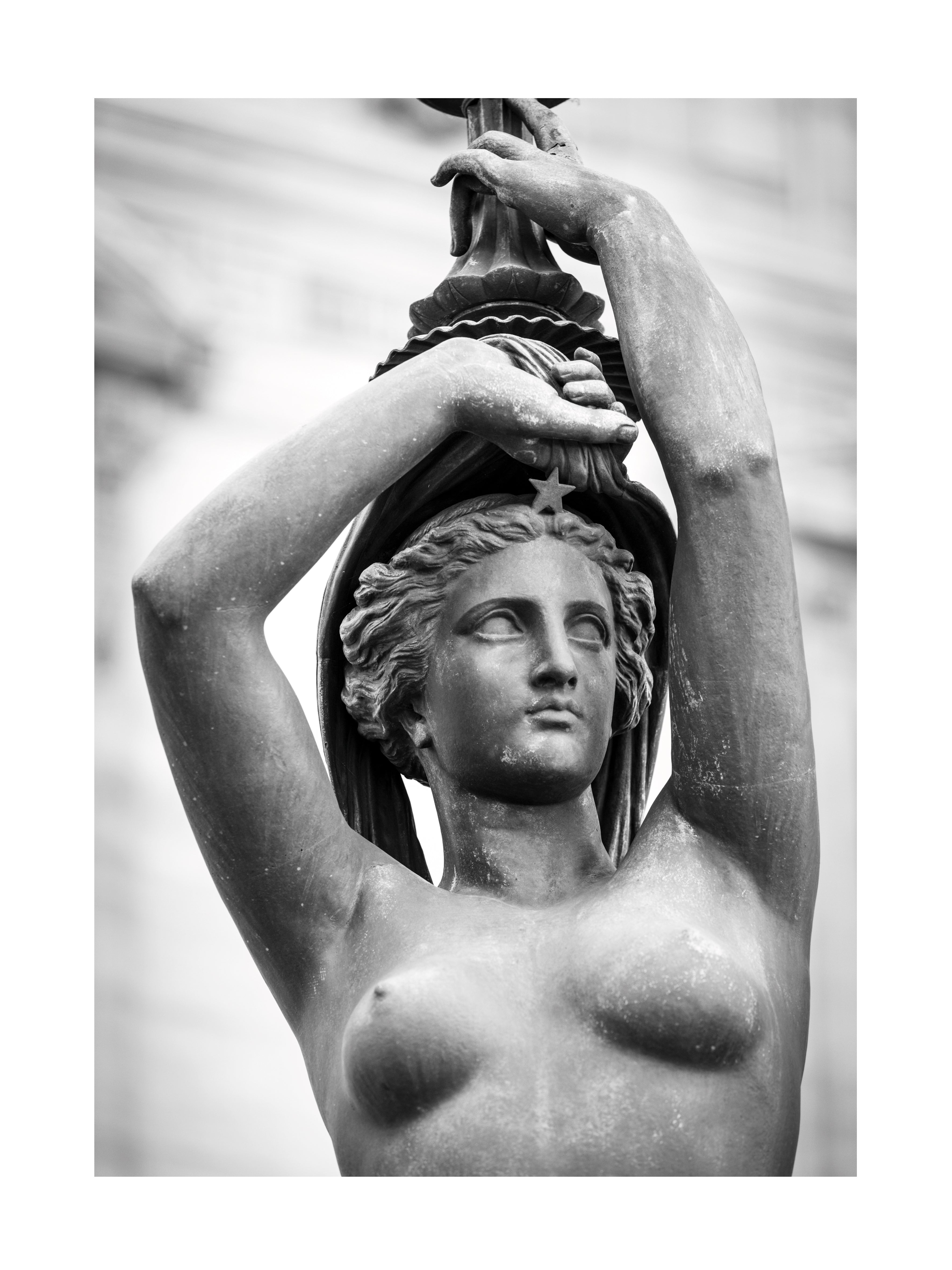Schwarz-weiße Fotografie einer Statue mit erhobenen Armen.