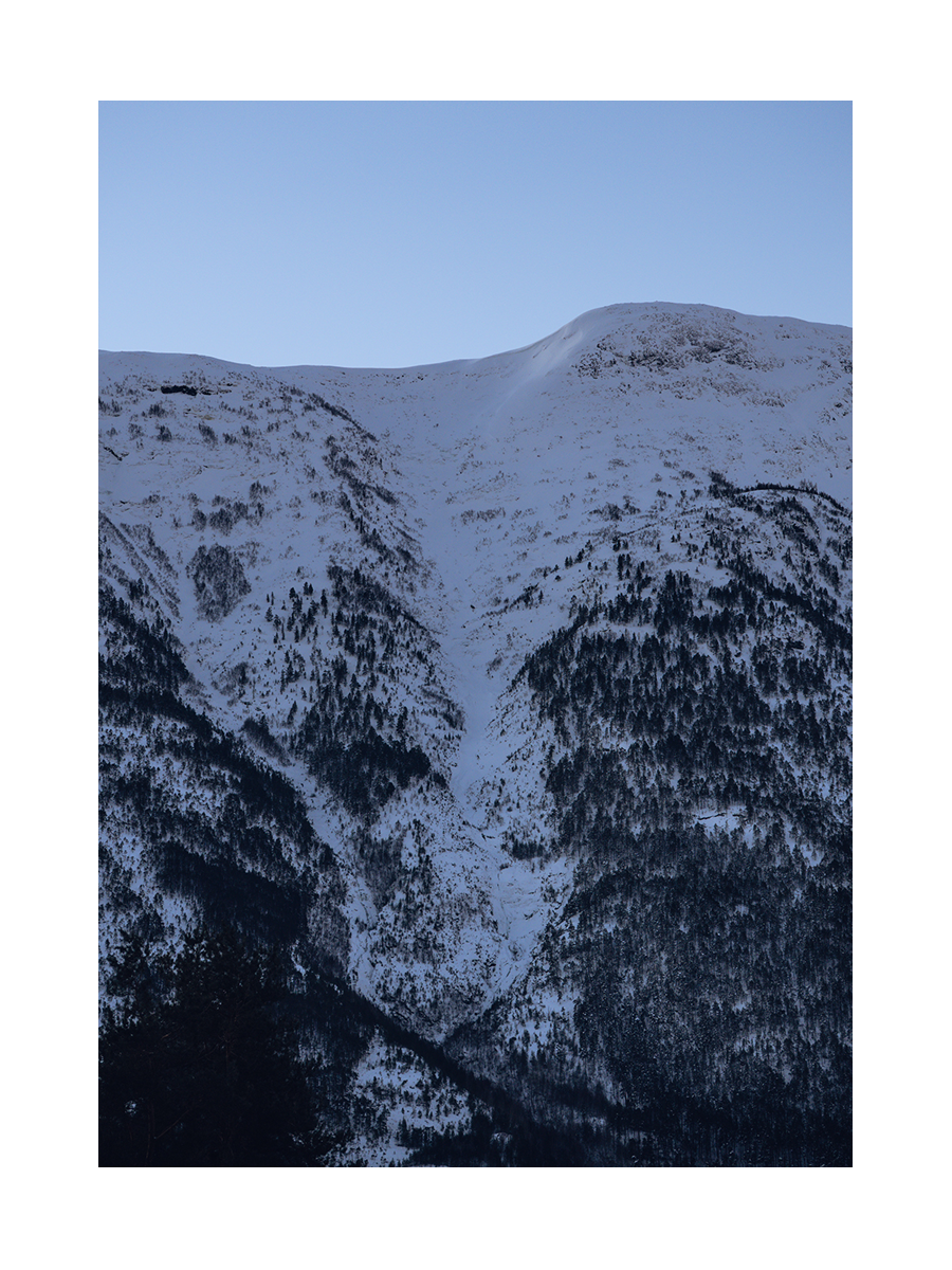 Fotografie von verschneiten Bergen mit klarem Himmel im Hintergrund.