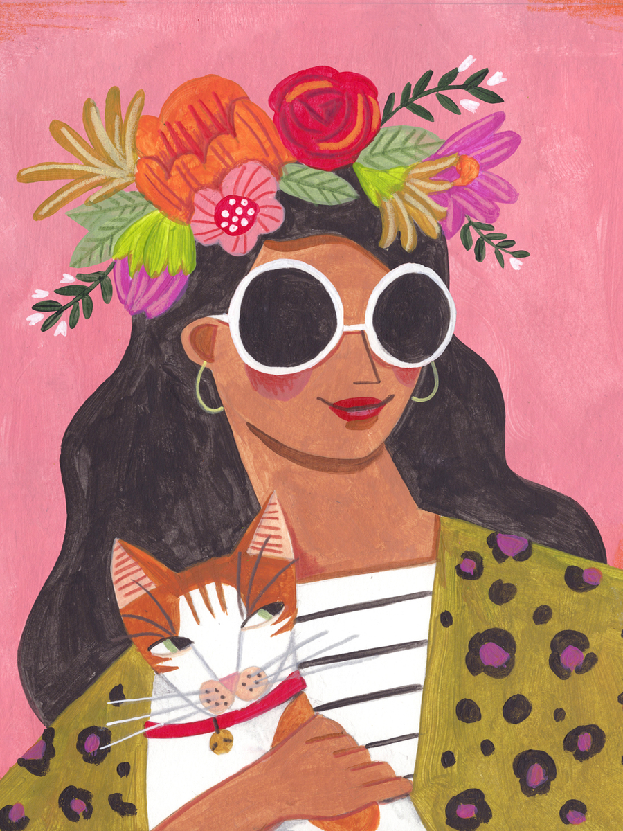 Frau mit Sonnenbrille und Blumenkranz hält eine Katze vor rosa Hintergrund.