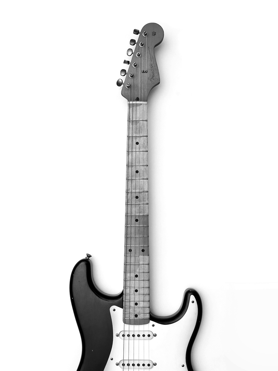 Schwarz-weiß-Fotografie einer E-Gitarre vor einem weißen Hintergrund.