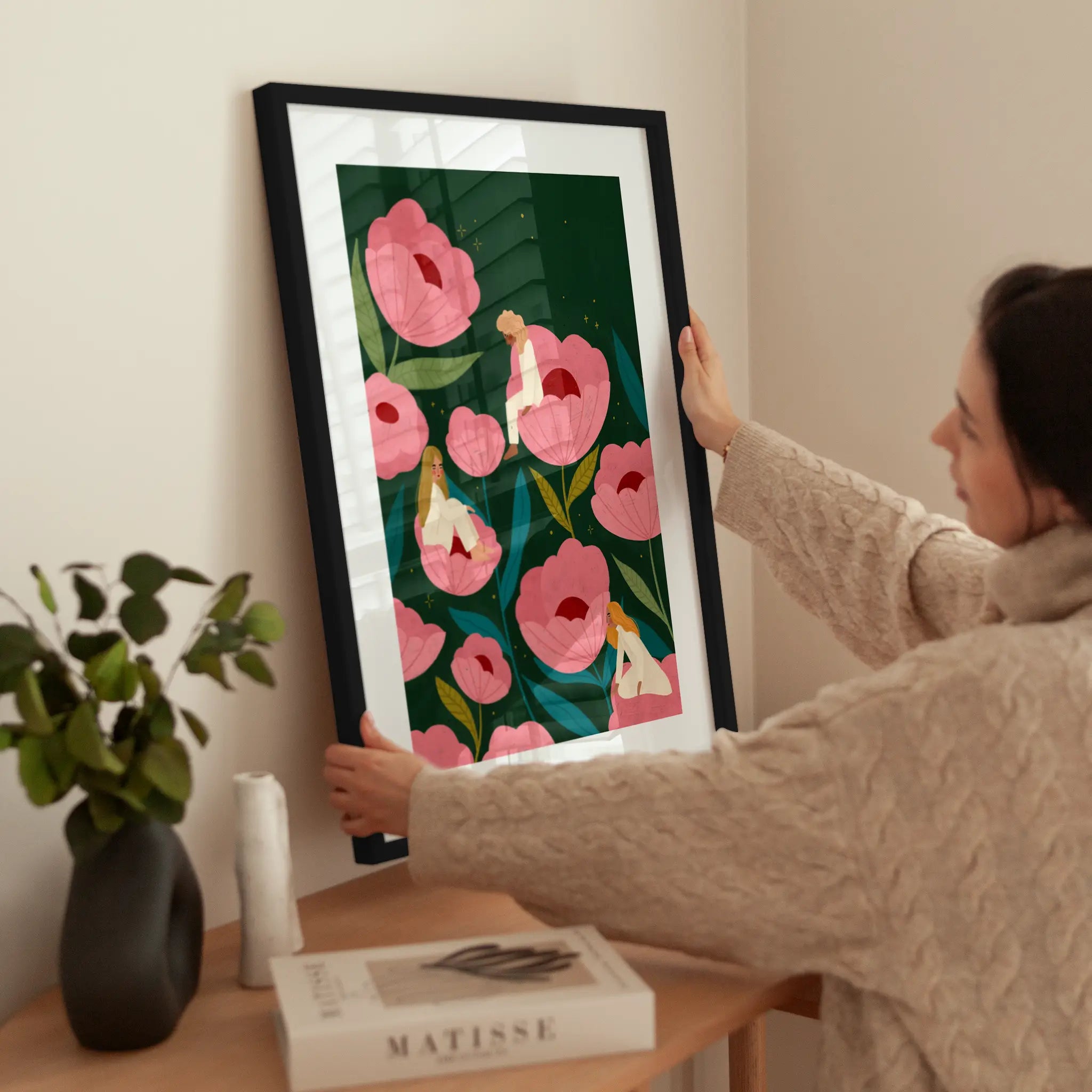 Three Women Sitting on Large Pink Flowers wird aufgehängt