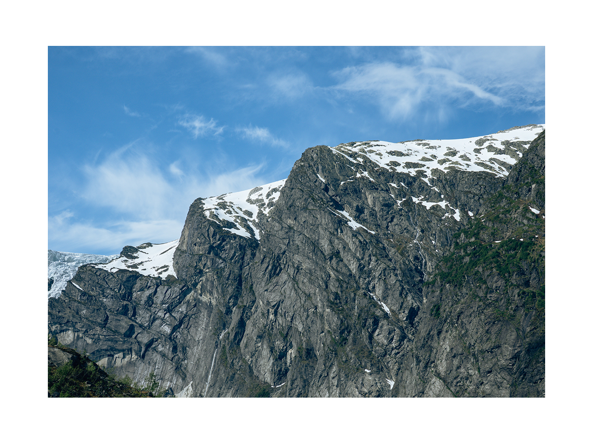 Fotografie von schneebedeckten Bergen unter einem blauen Himmel.