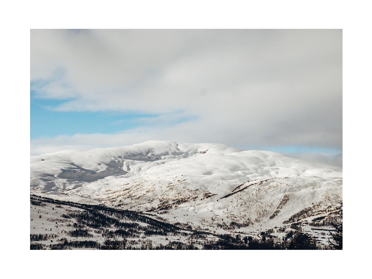 Fotografie von schneebedeckten Bergen mit blauem Himmel.