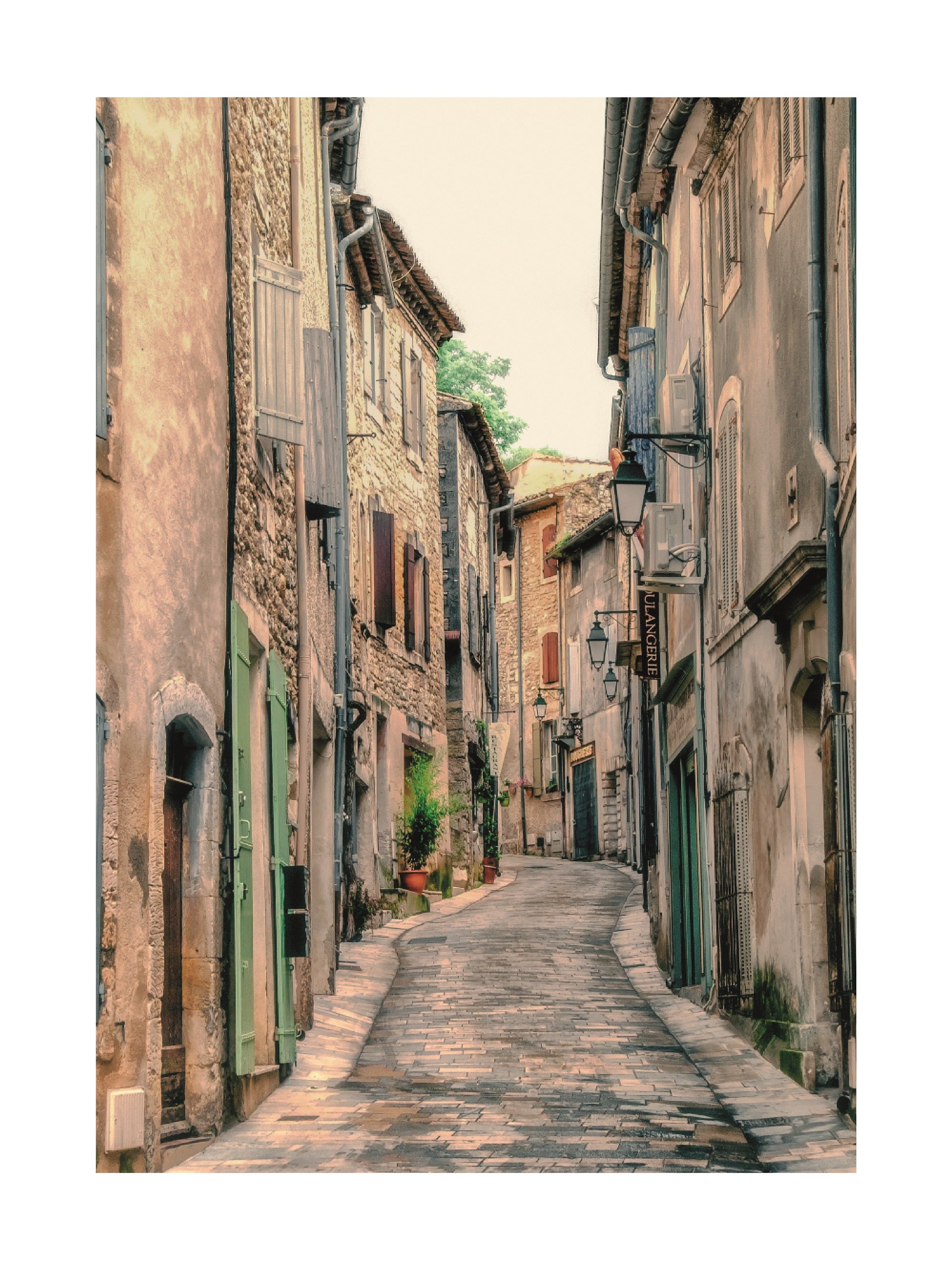 Fotografie einer schmalen Straße mit alten Gebäuden und Laternen in Frankreich.