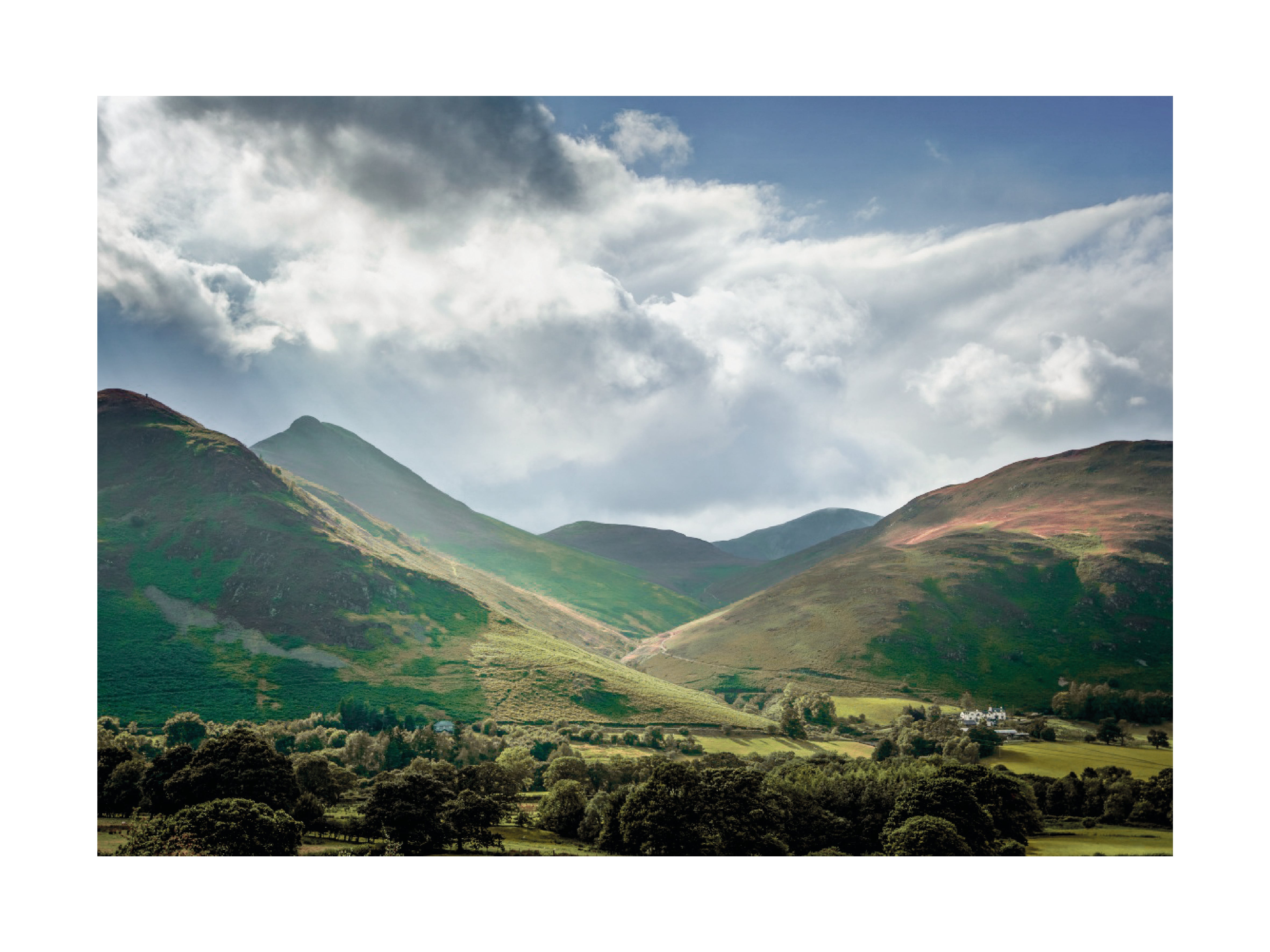 Fotografie der grünen Hügel im Lake District unter einem dramatischen Himmel.