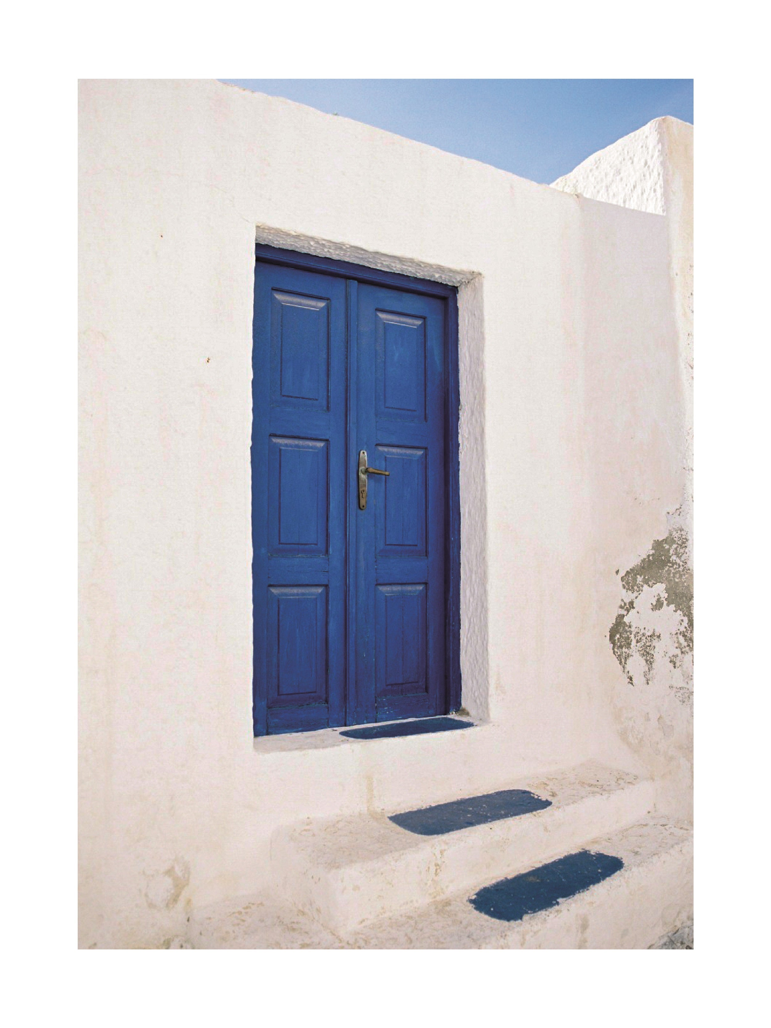 Fotografie einer blauen Tür mit blauen Stufen in einem weißen Gebäude.