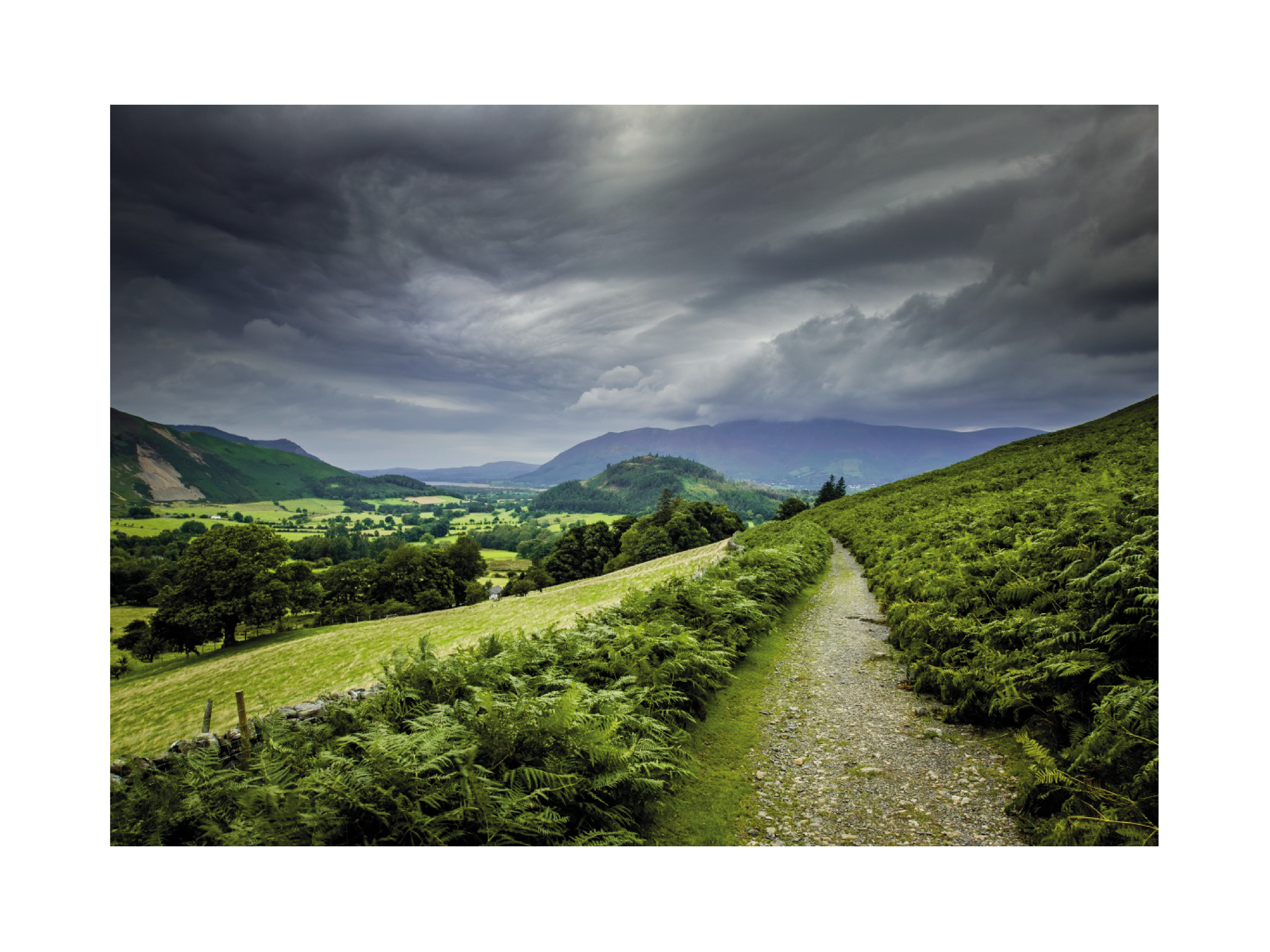 Landschaftsfoto des Lake Districts mit einem Pfad und dramatischen Wolken.