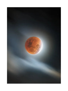 Fotografie des roten Mondes, umgeben von Wolken, vor einem dunklen Himmel.