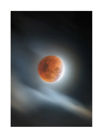 Fotografie des roten Mondes, umgeben von Wolken, vor einem dunklen Himmel.