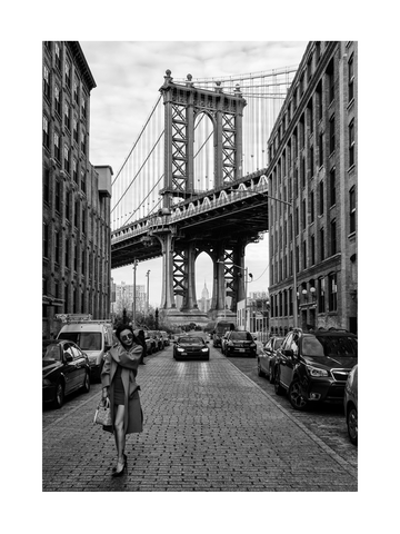 Schwarz-weiß-Fotografie einer Frau auf einer gepflasterten Straße mit der Manhattan Bridge im Hintergrund.