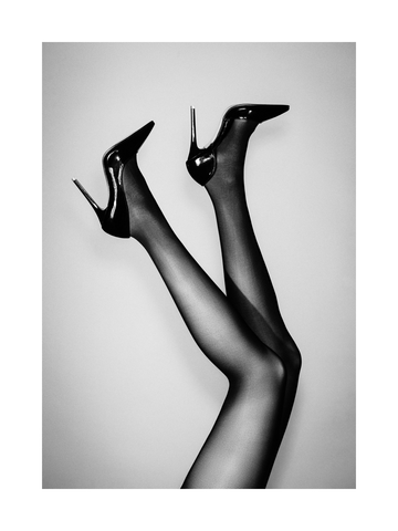 Schwarzweißfotografie von Frauenbeinen in Strumpfhosen und schwarzen High Heels.