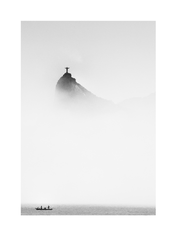 Schwarz-weiß-Fotografie der Christusstatue in Rio de Janeiro, umgeben von Nebel, mit einem Boot im Vordergrund.