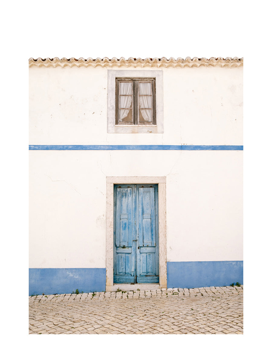 Fotografie eines blauen Hauses mit blauer Tür und einem Fenster.