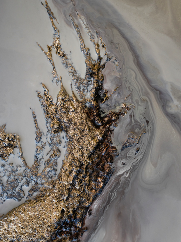 Abstrakte Kunst mit grauen und goldenen Farben in fließenden Formen.