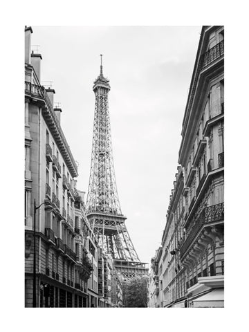 Schwarzweiß-Fotografie des Eiffelturms von einer Straße aus, gesäumt von Gebäuden.