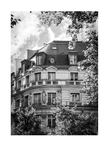 Schwarz-weiß-Fotografie eines Pariser Gebäudes mit bewölktem Himmel im Hintergrund.