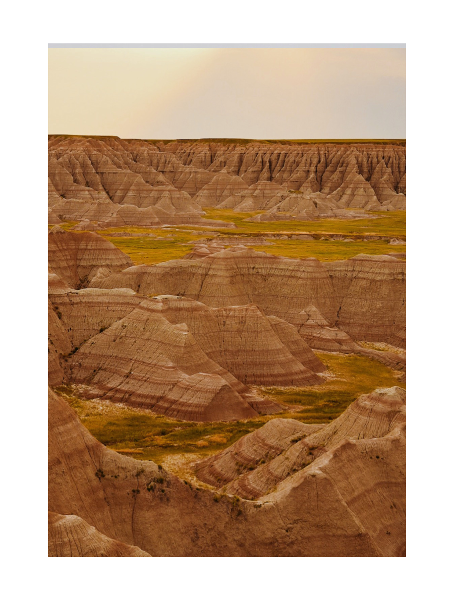 Fotografie der Badlands mit erodierten Felsformationen und weitem Himmel.