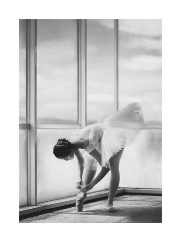 Schwarz-weiß-Fotografie einer Ballerina, die ihre Schuhe bindet.