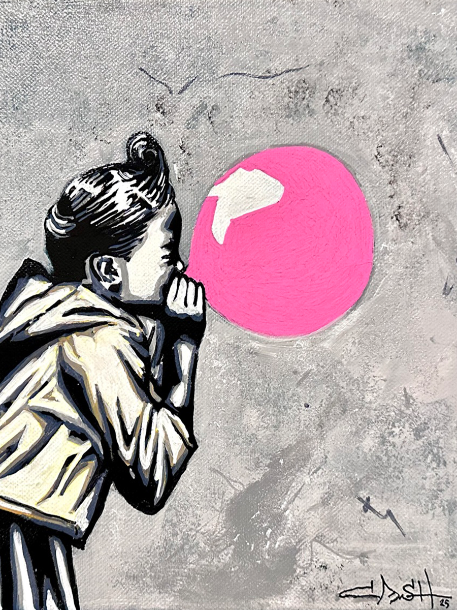 Ein kleines Mädchen bläst einen rosa Ballon auf einem grauen Hintergrund auf.