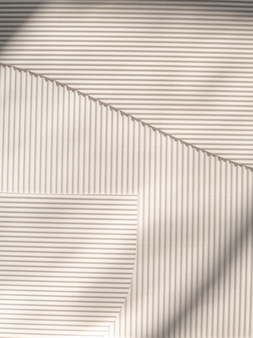 Abstrakte Fotografie von Licht und Schatten auf einer gestreiften Oberfläche.