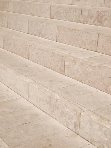 Fotografie von Treppenstufen in Marmoroptik mit neutralen Beigetönen.