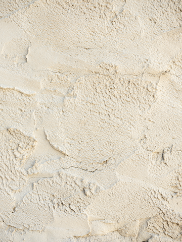 Beigefarbene Wand mit interessanter Struktur.