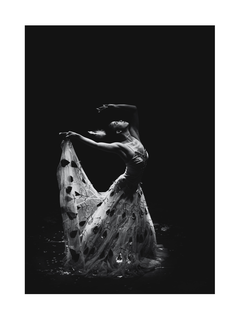 Schwarz-weiß-Fotografie einer Balletttänzerin in einem langen Kleid mit Blumenmuster.