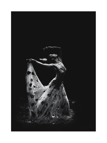 Schwarz-weiß-Fotografie einer Balletttänzerin in einem langen Kleid mit Blumenmuster.