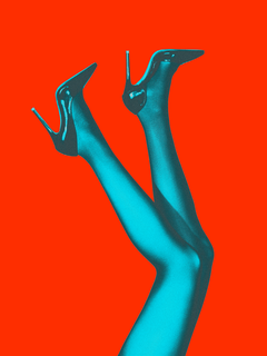 Beine in blauen hochhackigen Stiefeln auf rotem Hintergrund.