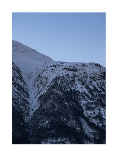 Fotografie von schneebedeckten Bergen mit klarem blauem Himmel.