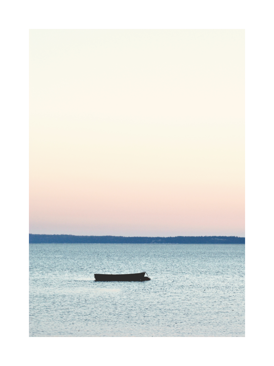 Foto eines Bootes auf einem ruhigen See bei Sonnenuntergang.