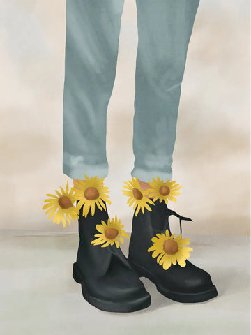 Beine in hellblauen Jeans und schwarzen Boots, die mit gelben Sonnenblumen geschmückt sind.