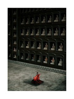 Frau in rotem Kleid in einem Raum mit buddhistischen Statuen.