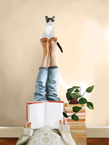 Frau liest ein Buch mit gestreckten Beinen, Katze sitzt auf ihren Füßen.