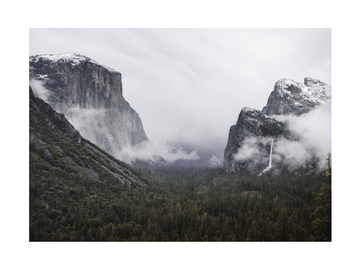 Fotografie des Yosemite-Tals mit Felsformationen und Wasserfall im Nebel.