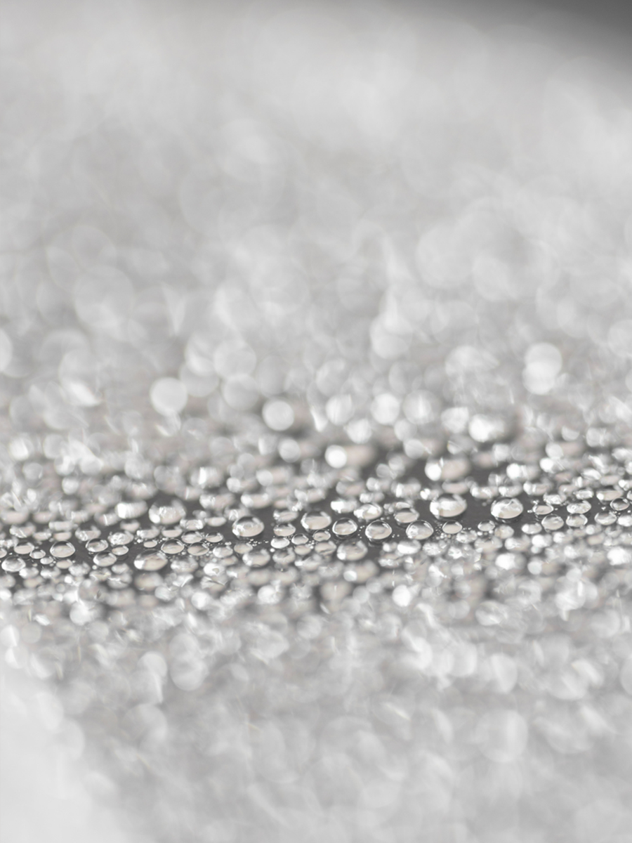 Nahaufnahme von Wassertropfen in unscharfem Grauton.