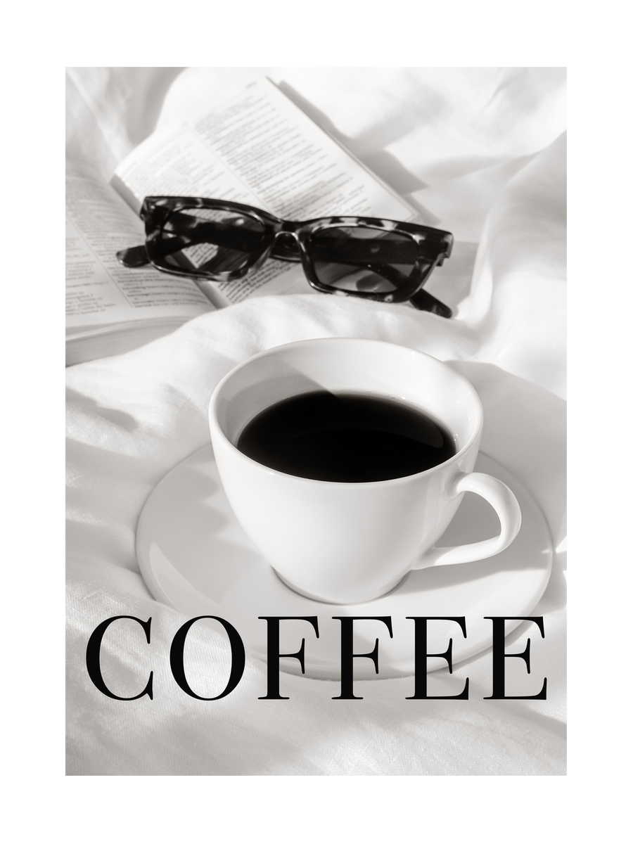 Eine Tasse Kaffee auf einem Bett mit einer Sonnenbrille und einem Buch daneben.