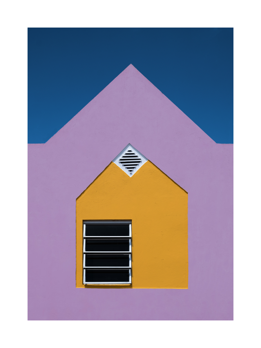 Fenster auf einer gelben und lila Wand vor einem blauen Himmel.