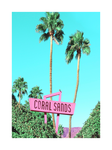 Fotografie eines rosa Schildes mit dem Text "Coral Sands" vor einem blauen Himmel und von Palmen umgeben.