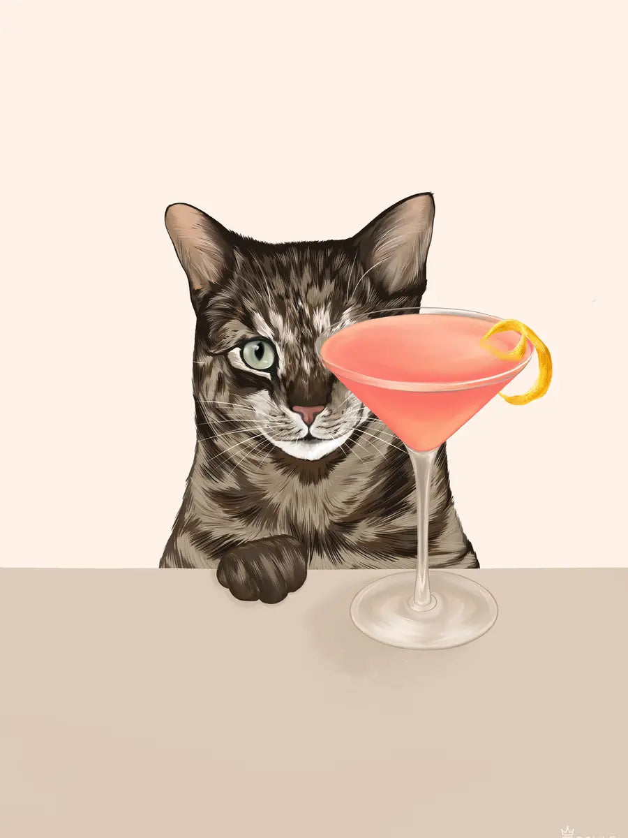 Eine Katze schaut neugierig auf einen rosa Cocktail vor einem hellbeigen Hintergrund.