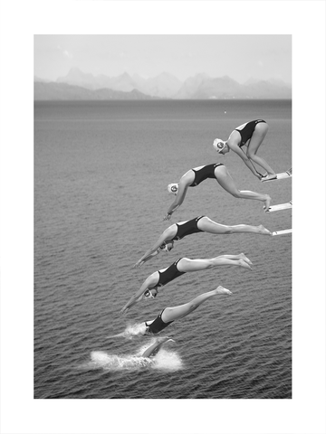 Schwarzweiß-Fotografie einer Frau, die in mehreren Phasen ins Wasser springt, mit einer Berglandschaft im Hintergrund.