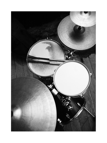 Schwarz-weiß-Fotografie eines Schlagzeugs von oben mit Besen und Filzstöcken.