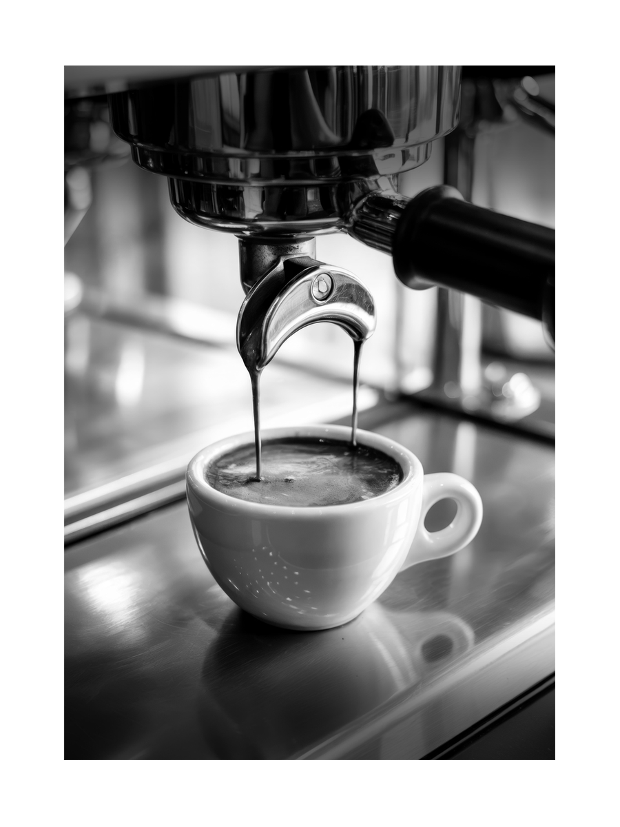 Schwarz-weißes Foto von Espresso, der in eine Tasse fließt.