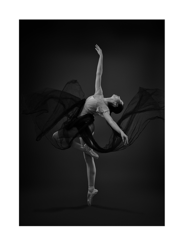Schwarz-weiß-Fotografie einer Ballerina in einem dunklen Tutu, die tanzt.