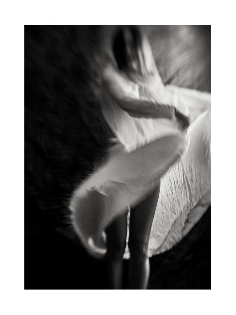 Schwarz-Weiß-Fotografie einer Person in Bewegung mit verschwommenen Details.